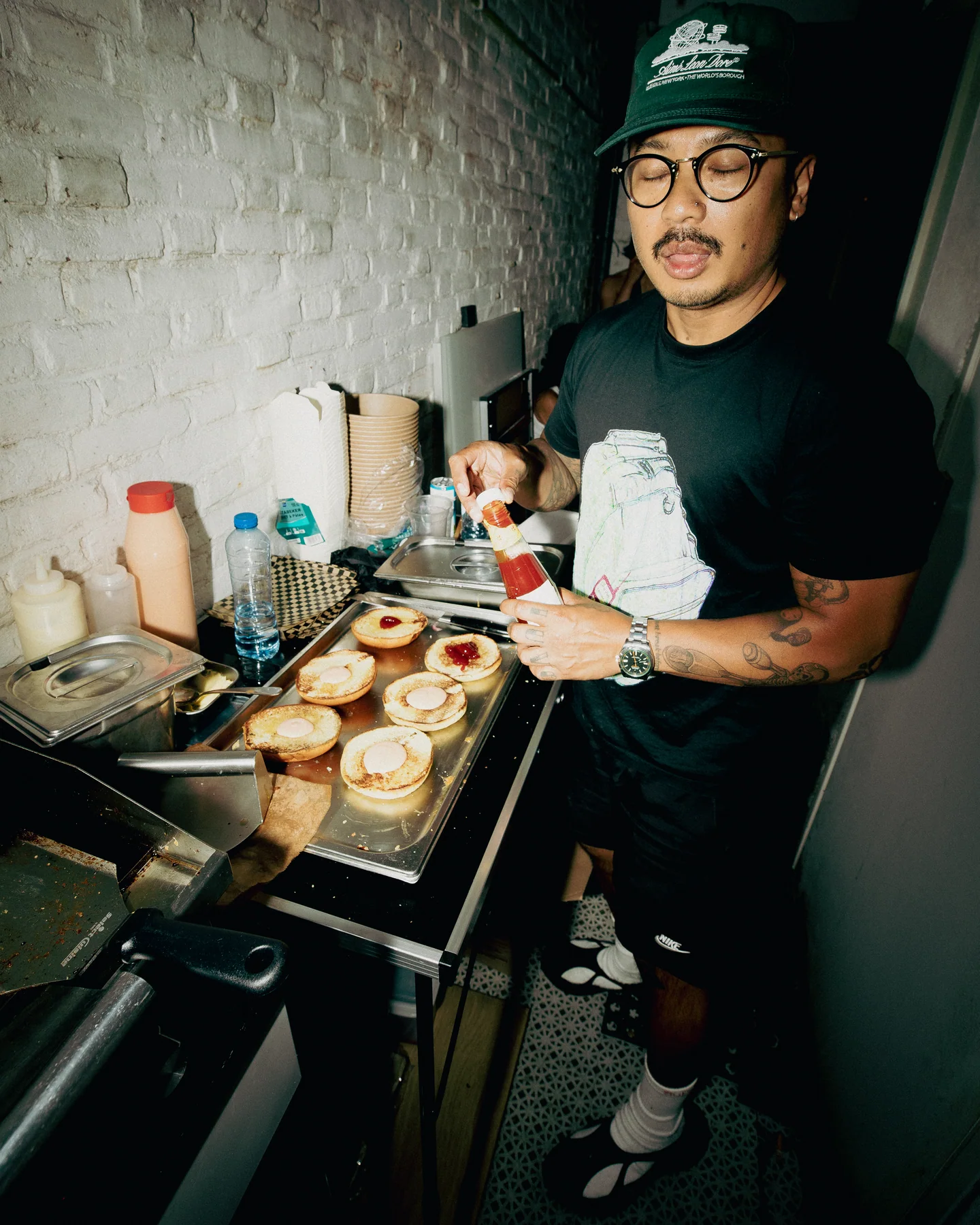 Guest holding food beside a preparation table at TAYO Community BBQ
