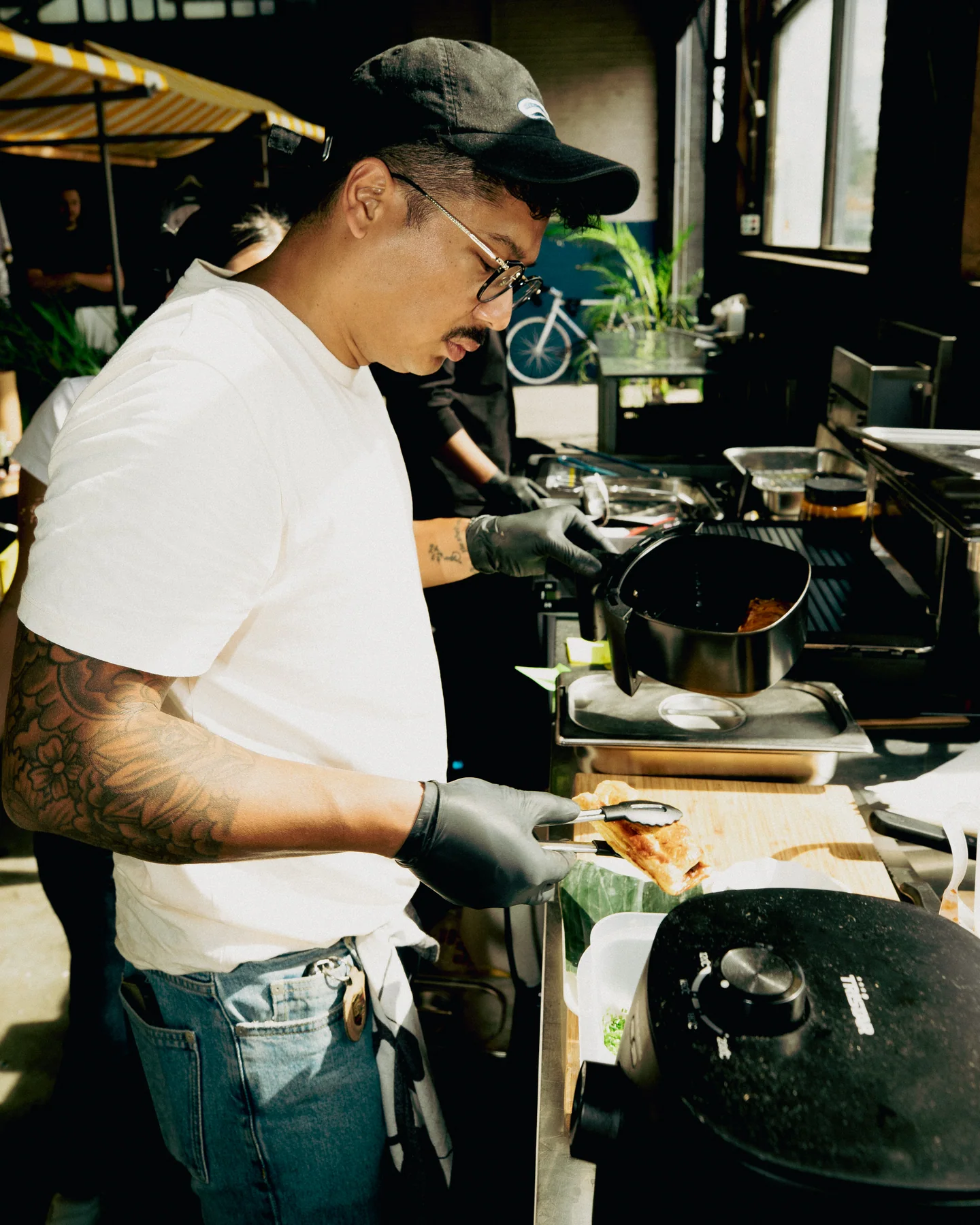 Guest cooking beside the food counter at Hapjesfestijn 2025