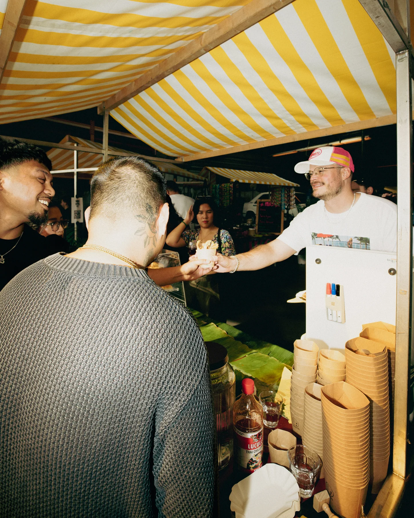 Guests talking across the food counter at Hapjesfestijn 2025
