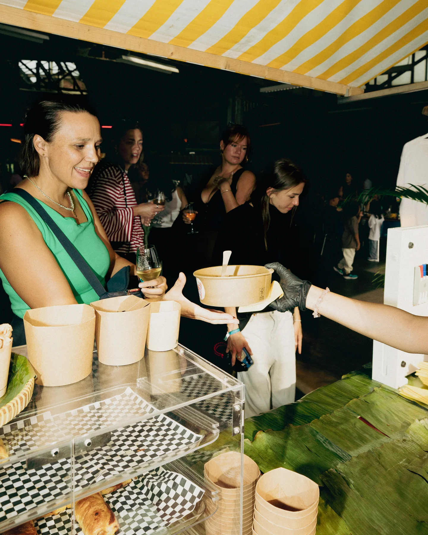 Guests arranging cups behind the food counter at Hapjesfestijn 2025