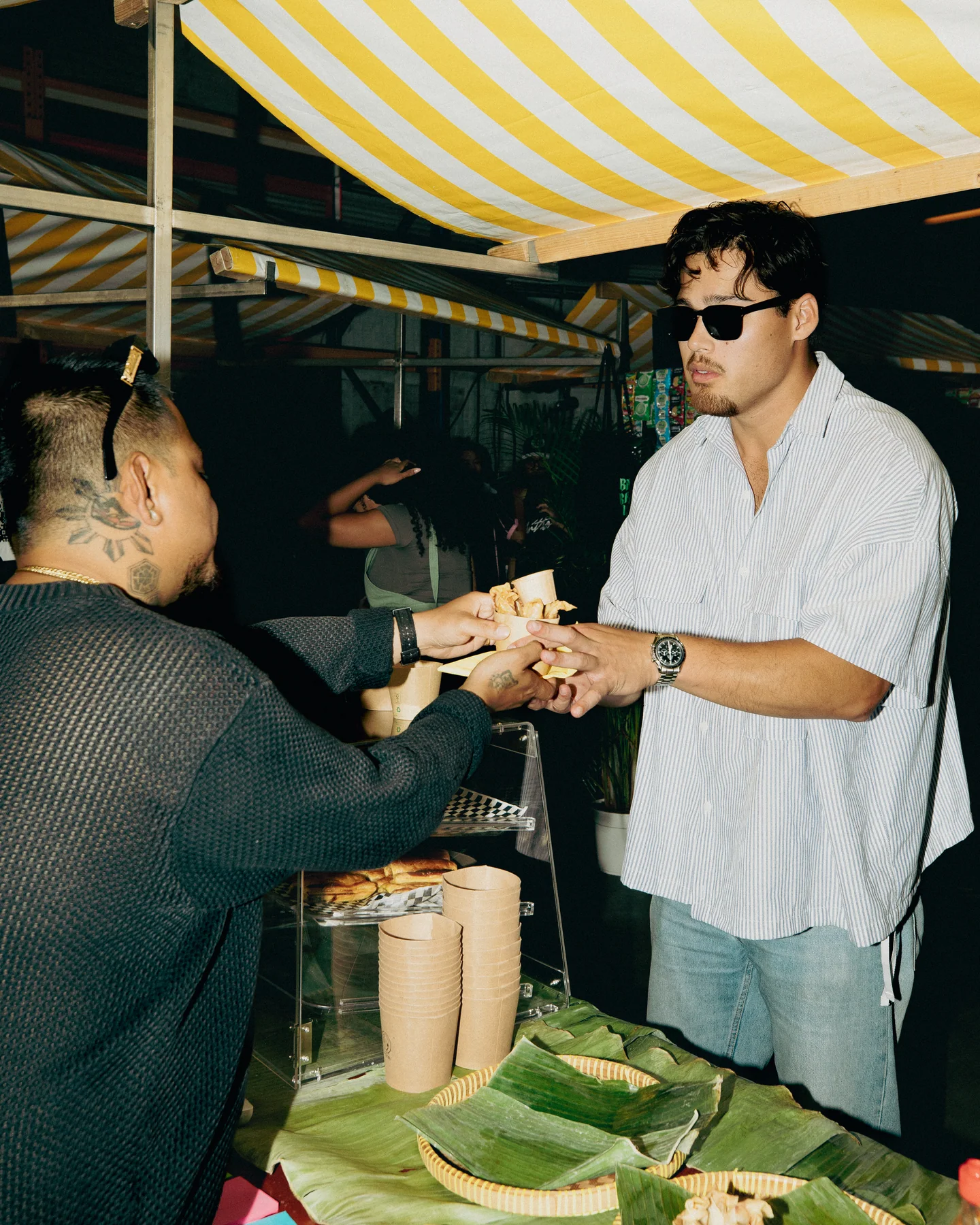 Food being handed to a guest beneath the canopy at Hapjesfestijn 2025