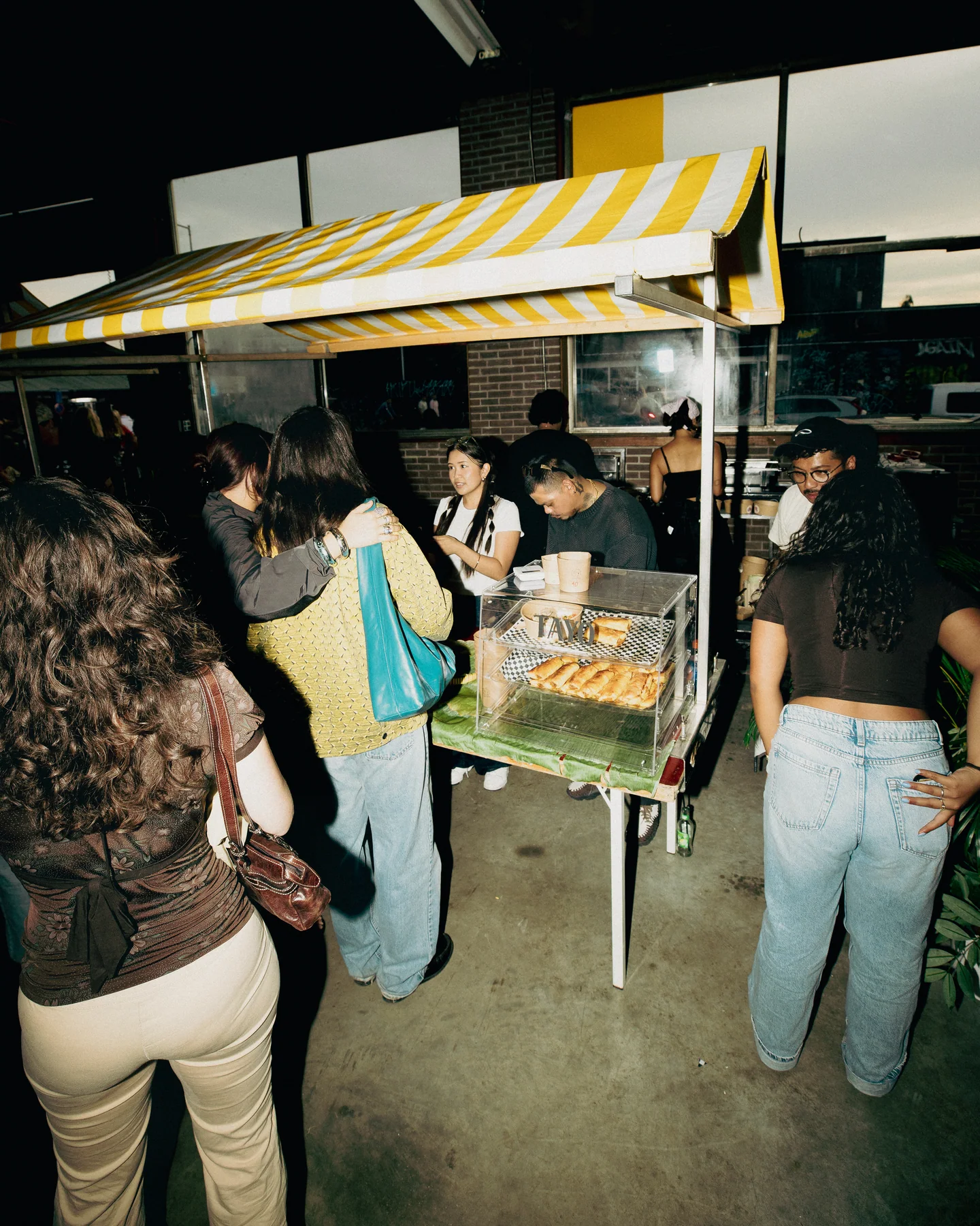 Guests visiting the stall beneath the striped canopy at Hapjesfestijn 2025