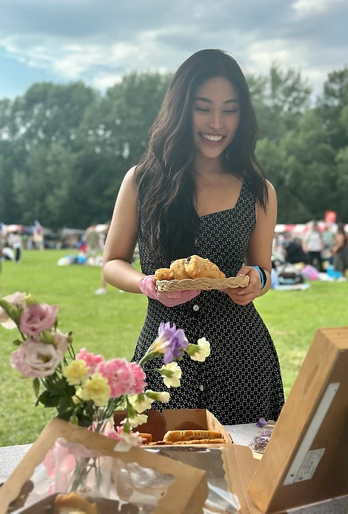 Jeanne outdoors with a table of bakes