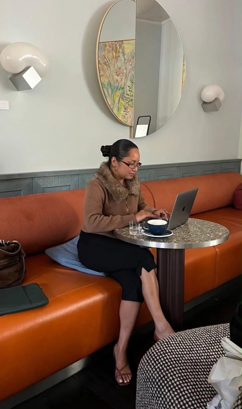 Robyn Lazala working on a laptop at a café table